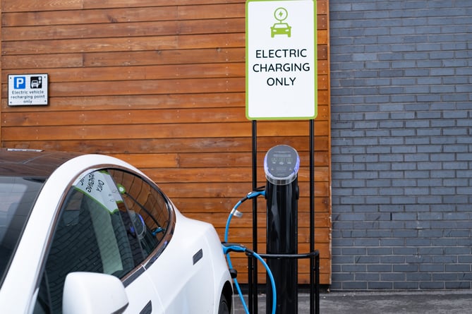 An electric car having its battery recharged at a public EV charging point in the UK.