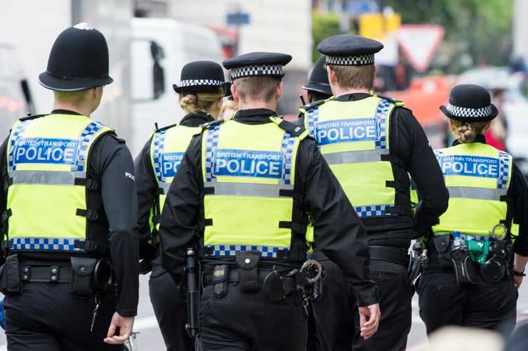 Six British Transport Police officers patrol the street in Highbury, London. 