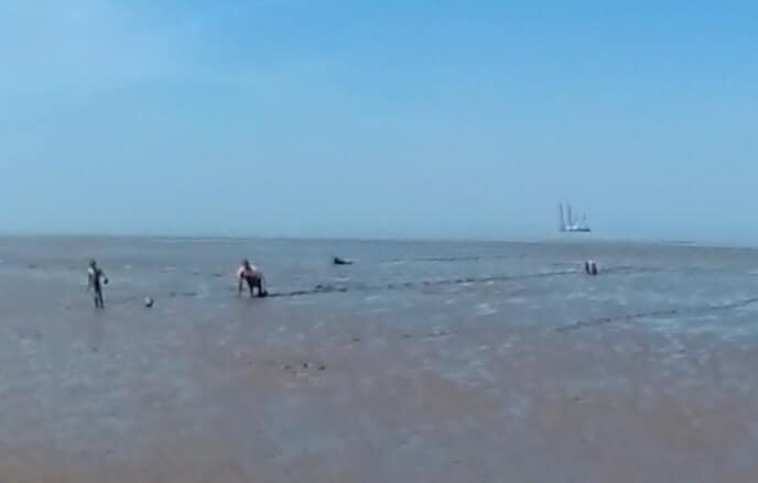 One of the families on Blue Anchor beach on Saturday struggling through the mud.