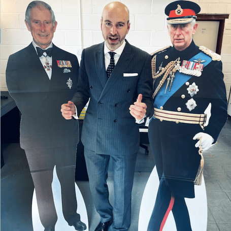 Porlock First Graphic Design boss Mark Padgett (centre) with the two life-size images of King Charles III coronation