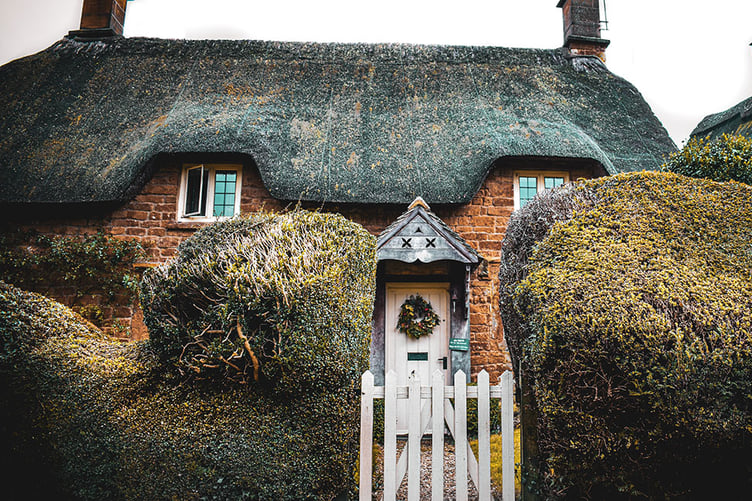 A thatched red brick cottage