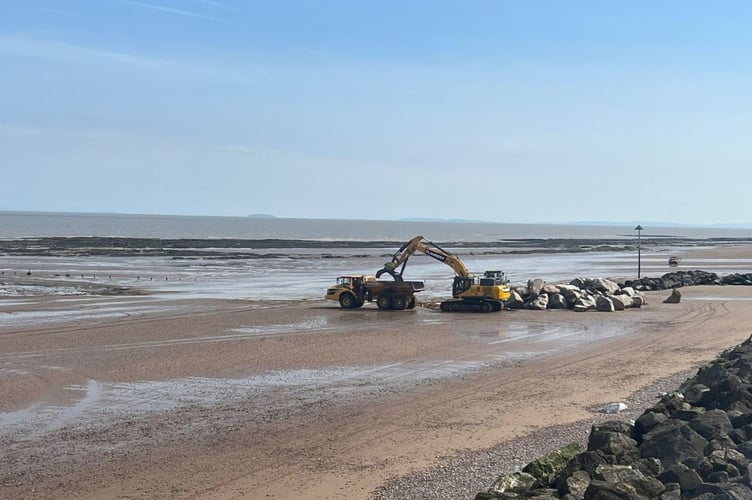 Heavy plant in action moving rock armour on Blue Anchor beach.