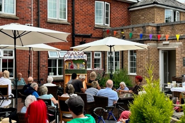 Residents and guests of the annual summer open day in Broadlands, Minehead, are entertained with a Punch and Judy show.
