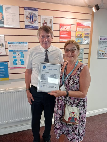 Alzheimer's ambassador Margaret Tatham presents a renewed membership certificate for Watchet and the Quantocks Dementia Action Alliance to Dr Andrew Allen.