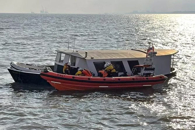 A RNLI lifeboat crew rescues two men from sinking boat out of Watchet.