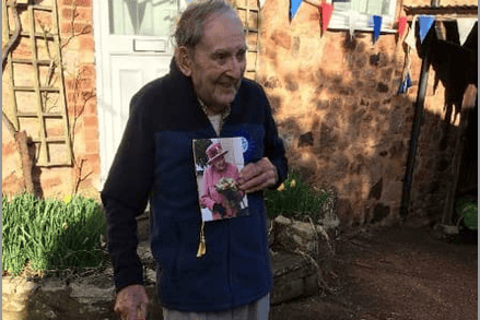 Bob Shire with a card from the Queen congratulating him on reaching 100 years of age.