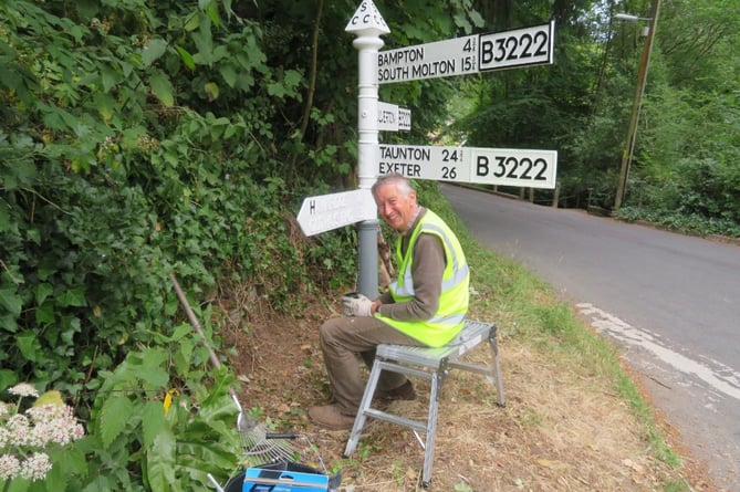 Volunteer and former Dulverton town councillor Piers Wood painting an Exmoor fingerpost at the bottom of Andrews Hill.