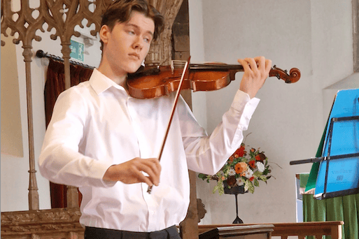 Violinist Anthony Knight performing at a Harvest Festival service in St Petrock's Church, Timberscombe.