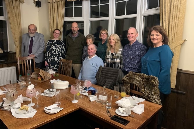 Richard Covey (seated) with his wife Jackie standing behind him, and past and present work colleagues at his retirement dinner.