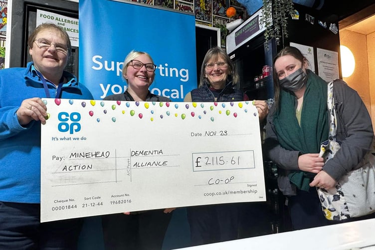 Co-op member pioneer for the Minehead and Williton area, Sarah Burnett, presents a cheque to Minehead Dementia Action Alliance.