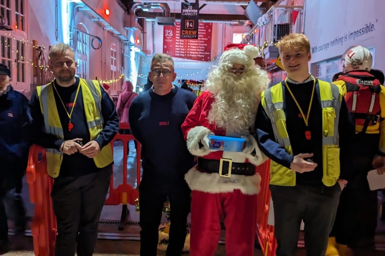 Pictured in Minehead RNLI boathouse are (left to right) helmsman Richard Huish, tractor driver/crewman David Legg, Santa, and crewman Ben Mouzouri.
