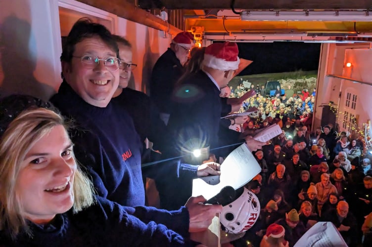 Enjoying 'Carols in the Boathouse' at Minehead RNLI are Thames commander/helmswoman Karla Thresher and station chairman Richard Newton.