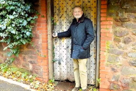 Former Minehead councillor Michael Burke at the side door of the Clanville gardens, in Holloway Street, in 2018. The door is now obscured by ivy.
