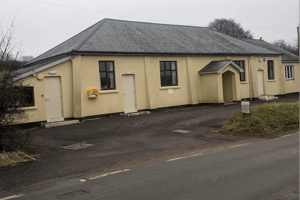 A defibrillator in its yellow casing can be seen fixed to the outside of Cutcombe's Moorland Hall, on Exmoor.