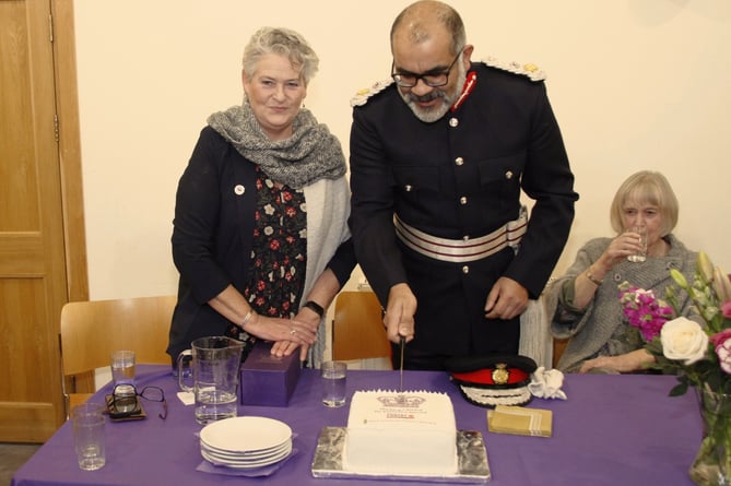 Somerset Lord Lieutenant Mohammed Saddiq cuts a celebratory cake flanked by West Somerset Food Cupboard trustees chairman Katrina Midgley (left) and founding trustee Jane Jones.