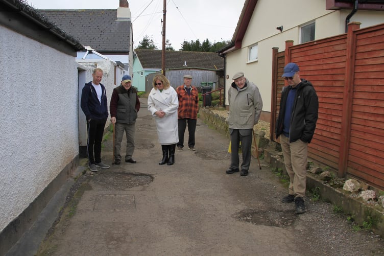 Residents in Whitehall, Watchet, examine their potholed road.