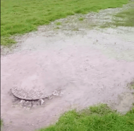 Raw sewage forcing itself through a sewer pipe manhole cover and running toward the River Avill, in Timberscombe. 