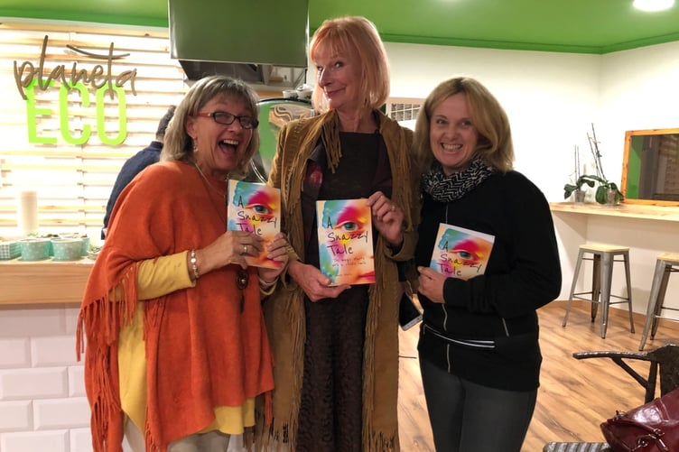 Lauren Station (left), founder of Snazaroo, with her book about the Minehead company and some of its readers.