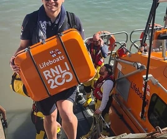 Ilfracombe RNLI crew members deliver the charity's 200th anniversary scroll to Minehead.