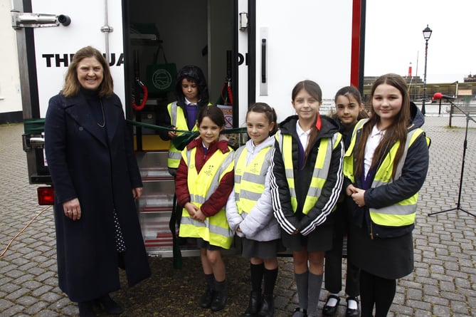 Somerset Deputy Lord Lieutenant Jennifer Duke with Stogumber and Crowcombe schoolchildren inspect Quantock Foodbank's electric van.