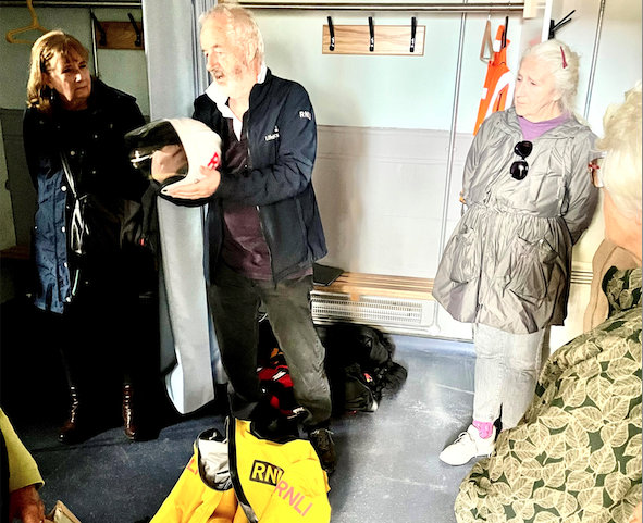 Minehead RNLI visits officer Eric Atkins explains some of the lifeboat crew's equipment to a visiting women's institute group. 