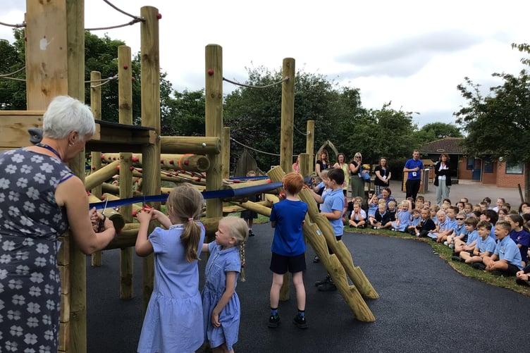 Getting ready to cut a ribbon to open new playground equipment at Knights Templar School, Watchet, are school council members watched by fellow pupils.