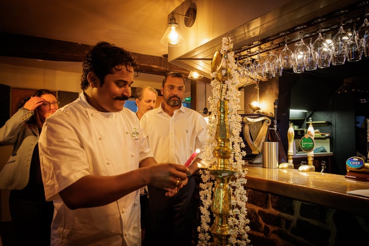 Chef Chanaka Fernando lights a candle wick set in coconut oil for a Puja ceremony at the reopening of The Rock Inn, Waterrow, near Wiveliscombe. PHOTO: Carlos Farinha.