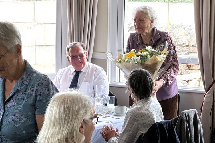 Caroline Giddens, founding member and secretary of Exmoor Natural History Society, receives a bouquet of flowers watched by vice-chairman Brian Coulson.