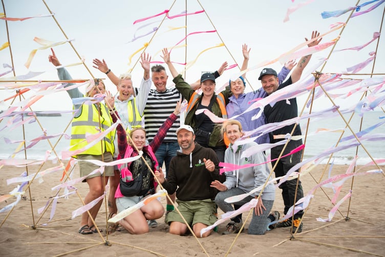 Sand artist Chris Oakey and helpers celebrate a Make A Wish creation on the beach as part of Minehead Bay Sand artist Chris Oakey and helpers celebrate a giant 'wish' creation on the beach as part of Minehead Bay Festival.