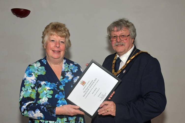 Moorland Food Bank founder Jenny Barker receives a community award from Somerset Council chairman Cllr Mike Best. PHOTO: Alain Lockyer.