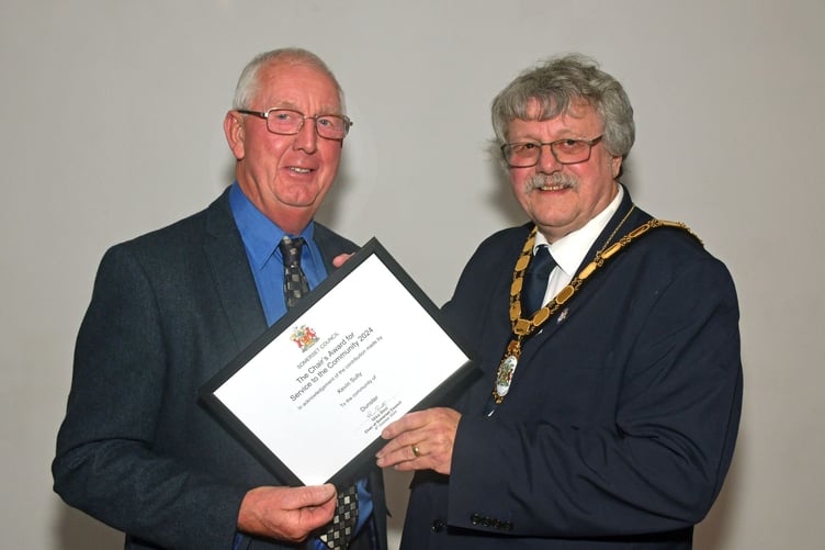 Dunster Parish Council vice-chairman Cllr Kevin Sully (left) receives a community award from Somerset Council chairman Cllr Mike Best. PHOTO: Alain Lockyer.