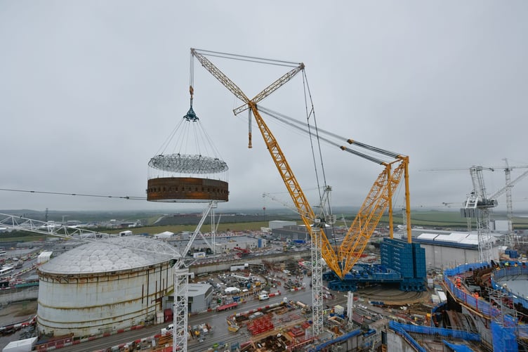 A steel liner ring hovers the Hinkley Point C nuclear power station site as it is moved into the second reactor building by giant crane Big Carl. PHOTO: EDF.