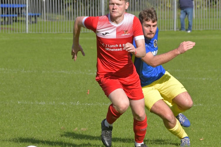 Ollie Morris who scored Porlock's second goal beats a Wagtail defender to the ball (Photo Alain Lockyer)