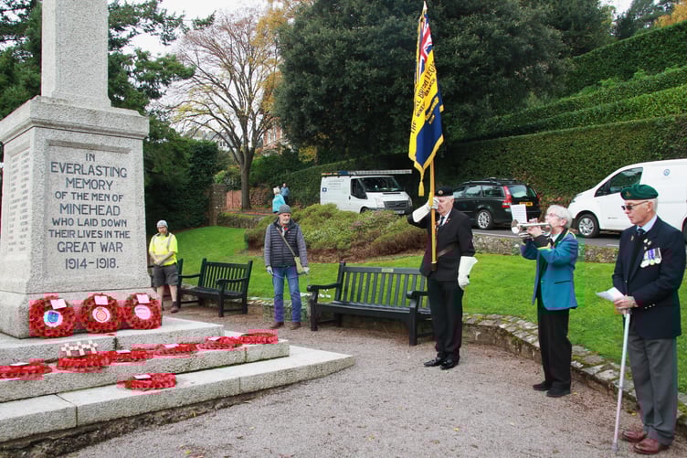 Pictured at the Armistice Day two-minute silence around Minehead’s North Hill war memorial are Royal British Legion standard bearer Neil Kendall with legion vice-chairman Phillip Collins and bugler Jenny Shelton, of the West Somerset Brass Band. PHOTO: George Ody.