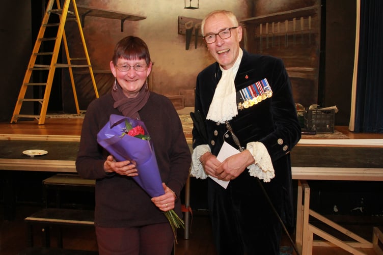 Roadwater Shop volunteer Sandy Towler receives a bouquet of flowers from High Sheriff of Somerset Rob Beckley. PHOTO: George Ody.