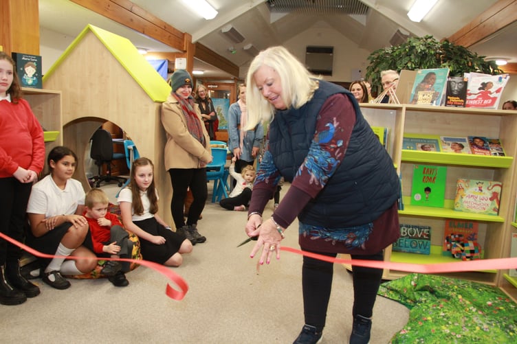 Dulverton Town Council chairman Cllr Christine Dubery performs a ribbon cutting to open a new school library. PHOTO: George Ody.