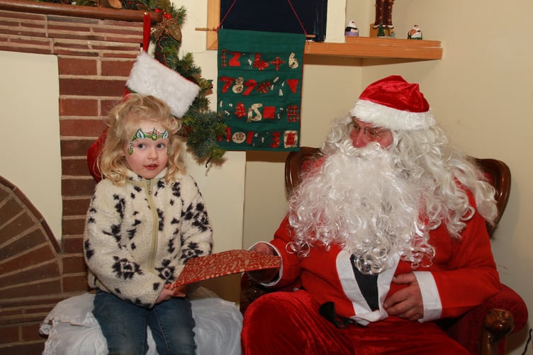 Skyla Fisher meets Santa in his grotto during Porlock's late night Christmas shopping evening. PHOTO: George Ody.