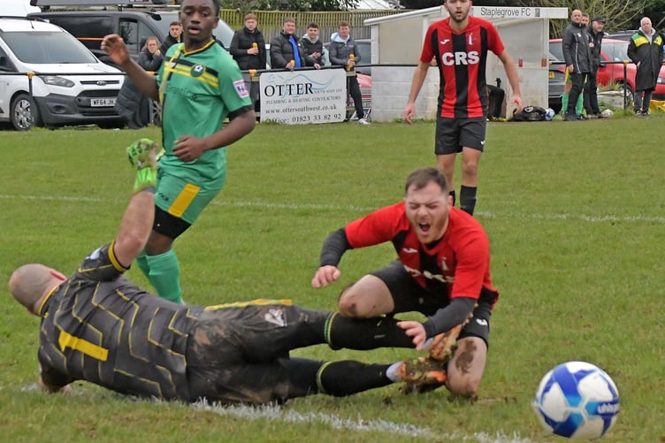 Watchet Town's two-goal striker Billy Jones clashes with the Grove goalkeeper