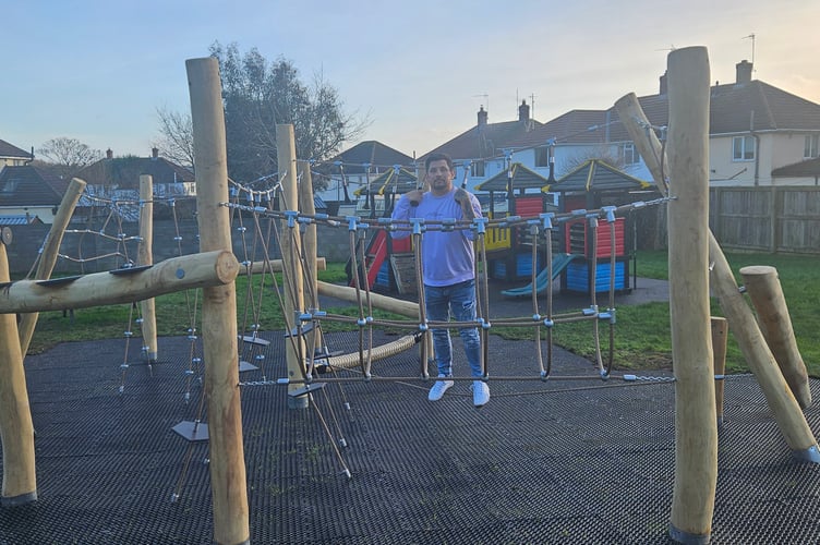 Watchet town Cllr Sean Terrett tries out a new piece of equipment in a children's play area. PHOTO: WTC.