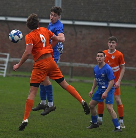 Minehead's Man of the Match Will Singleton-Voss heads for goal with Matt Trump looking on