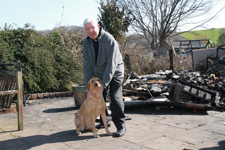 The Rev John Thorogood with Lulu the Labrador dog at his fire damaged home in Withycombe. PHOTO: George Ody.