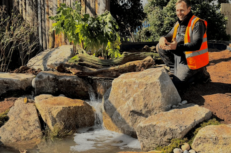 One of the aquatic landscape team surveys bobcat Bode's newly-built water feature at Tropiquaria Zoo.