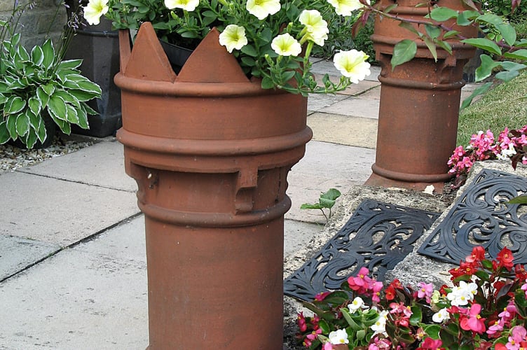 A new use as flower planters for some old chimney pots.