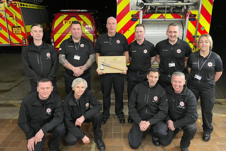 Retiring Nether Stowey watch manager Nick Rich is flanked by firefighting colleagues. PHOTO: DSFR.