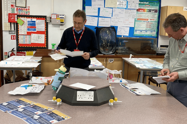 Dr Stephen Colson (left) assesses entries in Minehead Middle School's science contest.