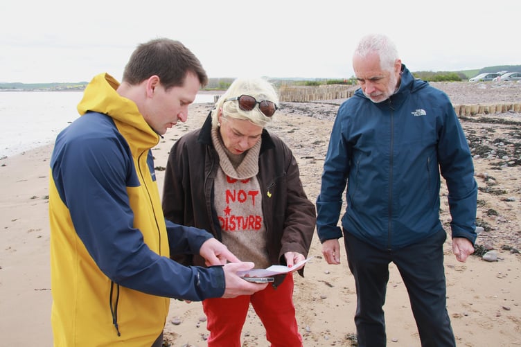 The results of real time testing of water off Dunster Beach are checked by MP Rachel Gilmour and Molendotech's Simon Jackson (left) and Christian Good. PHOTO: George Ody.