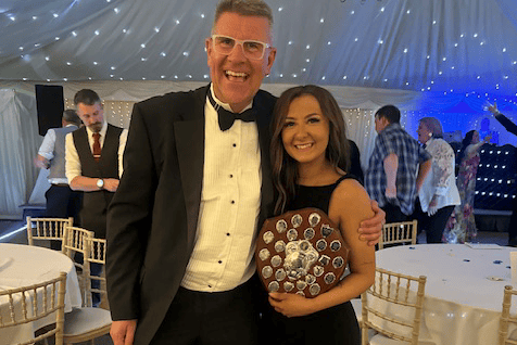 Minehead Panto People's Sleeping Beauty director Darcy Ahern collects her 'best director' shield from adjudicator Lee Baker at the Somerset Fellowship of Drama Cinderella awards.