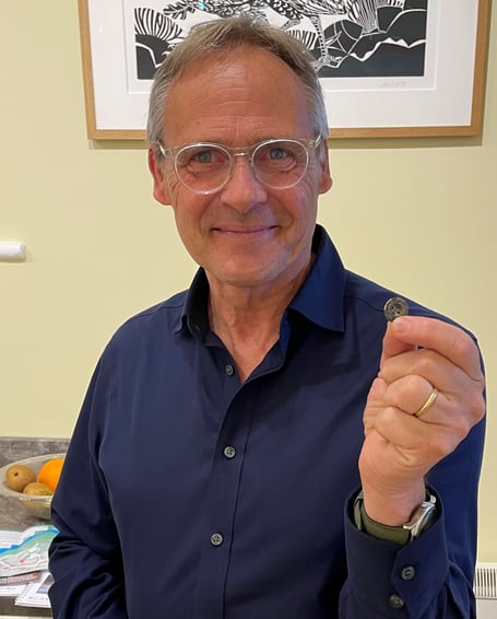 Peter Parminter holds a button which had been lost in Dulverton by his great-grandfather more than a century ago. PHOTO: DWLC.