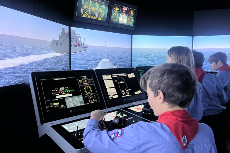 Watchet sea scouts experienced taking the helm of a warship in a bridge simulator during a visit to the Britannia Royal Naval College.
