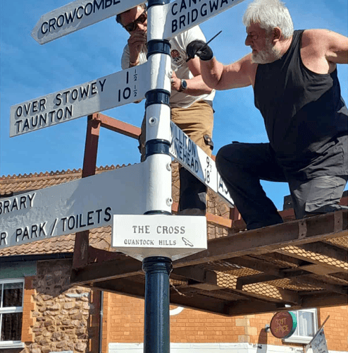 The finishing touches being put to a restored fingerpost in the centre of Nether Stowey. PHOTO: Nether Stowey Parish Council.
